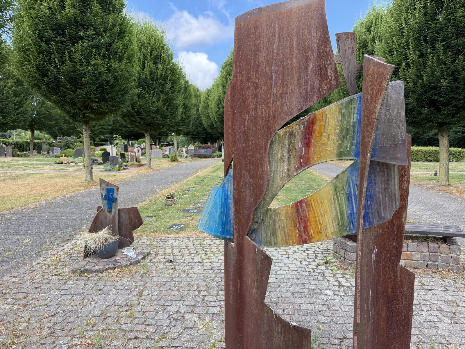 Holzkunstwerk mit Farbglas auf dem Friedhof Buldern